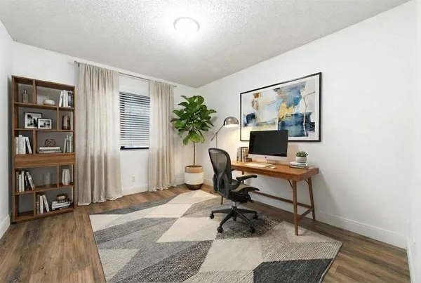 a workspace with wooden floor and a rug