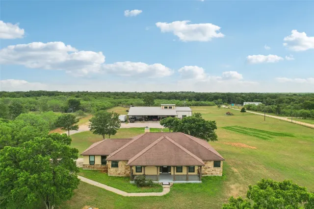 a aerial view of a house with big yard and large trees