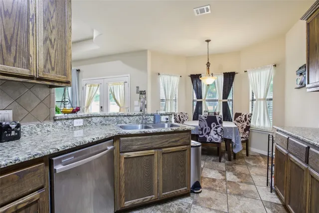 a kitchen with stainless steel appliances granite countertop a sink stove and cabinets