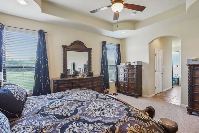 a bedroom with a bed dresser and a large mirror