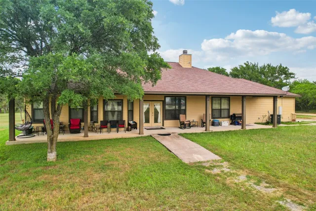 a view of a house with a yard patio and fire pit