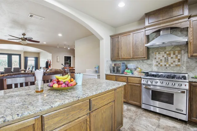 a kitchen with stainless steel appliances granite countertop a stove and cabinets