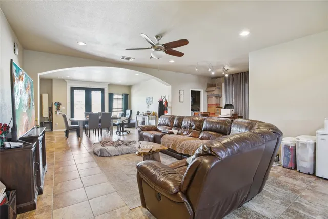 a living room with furniture and a view of kitchen