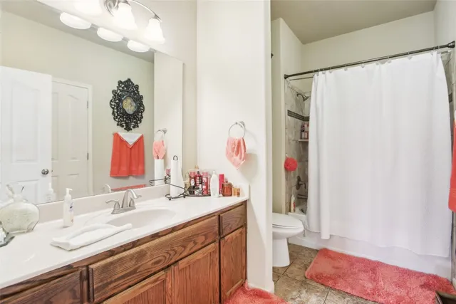 a bathroom with a sink vanity mirror and toilet