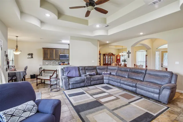 a living room with furniture and a view of kitchen