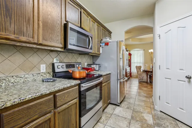 a kitchen with stainless steel appliances granite countertop a sink stove and cabinets