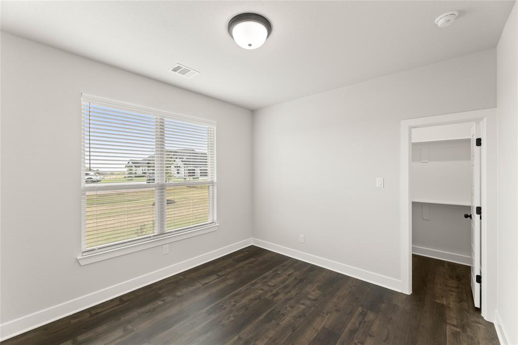 441 Collum View Azle, TX 76020 - Photo 16 of 38 Unfurnished bedroom featuring dark wood finished floors and a spacious closet