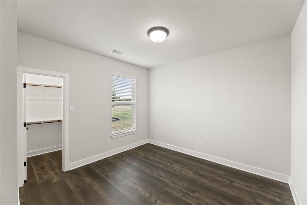 441 Collum View Azle, TX 76020 - Photo 18 of 38 Unfurnished bedroom featuring dark wood finished floors and a spacious closet