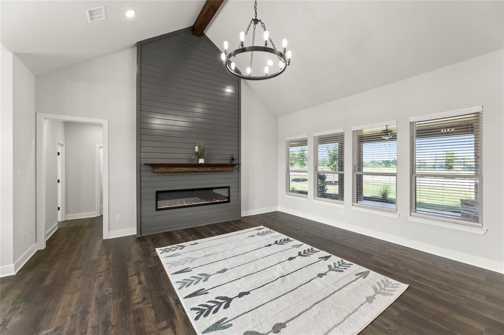 441 Collum View Azle, TX 76020 - Photo 6 of 38 Living area featuring high vaulted ceiling, beamed ceiling, a chandelier, dark wood-style floors, and a large fireplace
