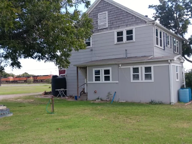 a backyard of a house with table and chairs