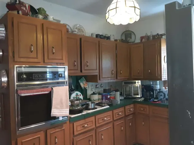 a kitchen with granite countertop a refrigerator a stove a sink and dishwasher with wooden floor