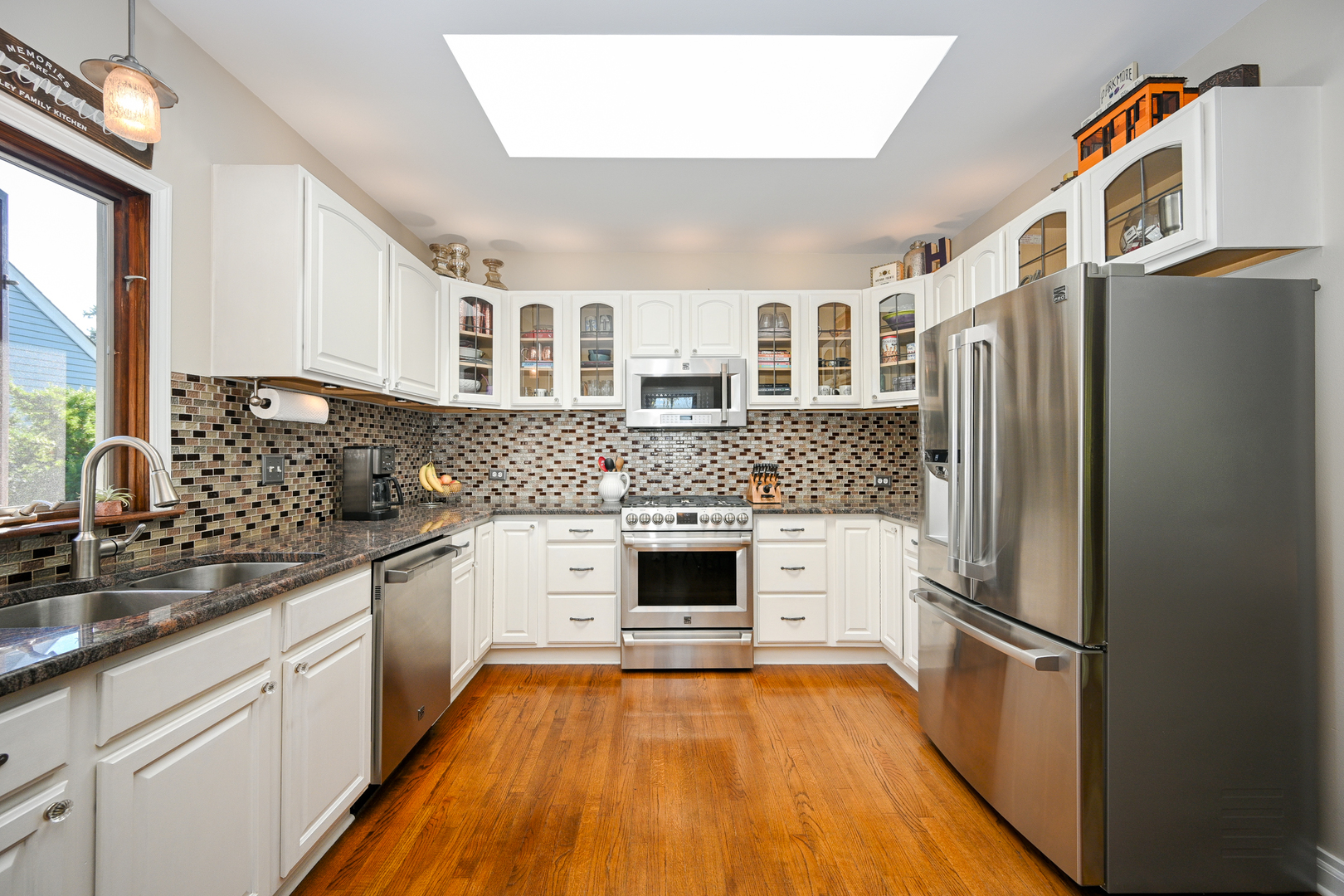 22W474 Emerson Avenue Glen Ellyn, IL 60137 - Photo 12 of 42 a kitchen with stainless steel appliances white cabinets and wooden floor