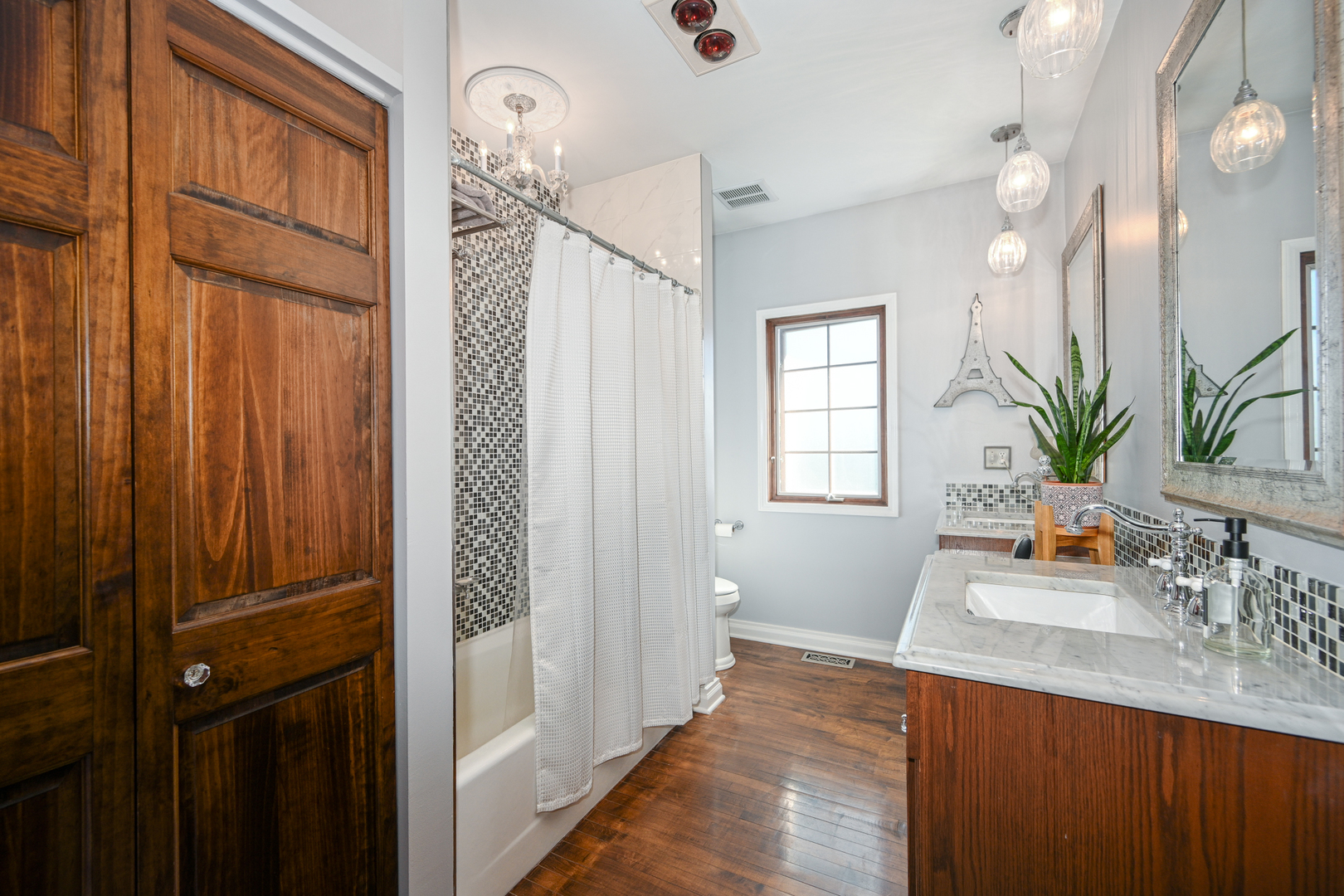 22W474 Emerson Avenue Glen Ellyn, IL 60137 - Photo 17 of 42 a bathroom with a sink a mirror and a shower