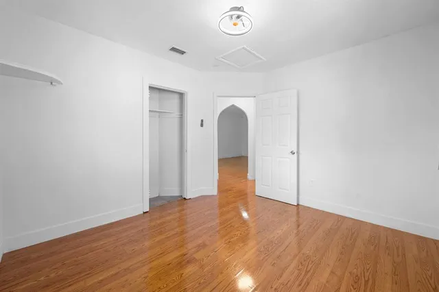 a view of empty room with wooden floor