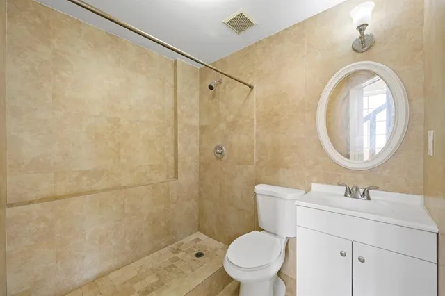 a bathroom with a sink a mirror a toilet and a shower