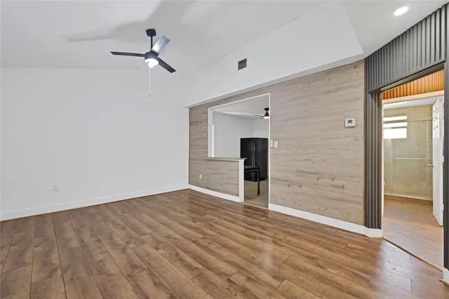 a view of empty room with wooden floor and fireplace