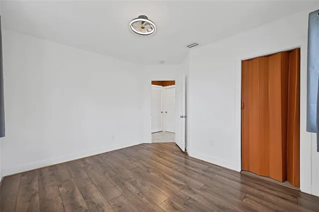a view of empty room with wooden floor