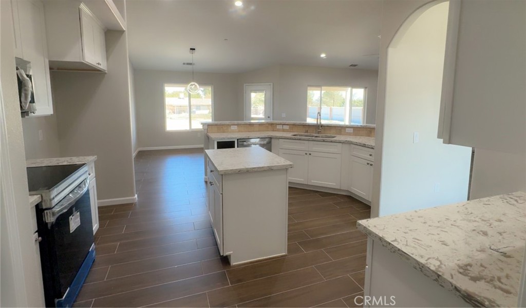 16506 Cactus Street Hesperia, CA 92345 - Photo 14 of 34 a kitchen with cabinets and wooden floor