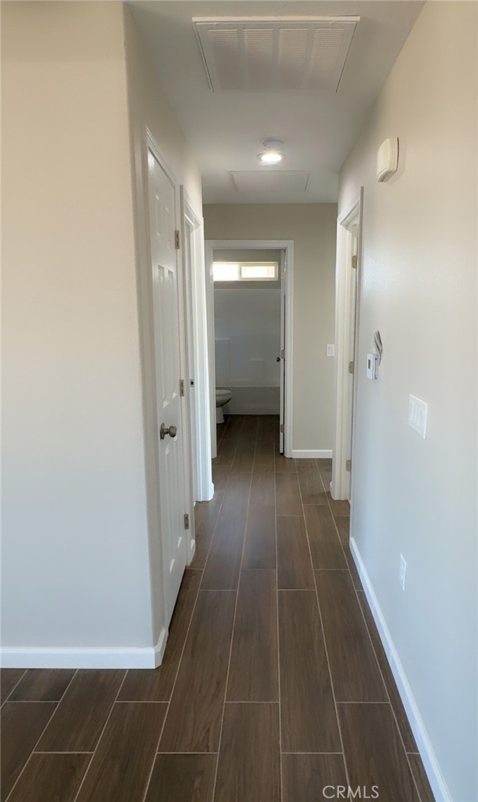 16506 Cactus Street Hesperia, CA 92345 - Photo 22 of 34 a view of a hallway with wooden floor and a bathroom