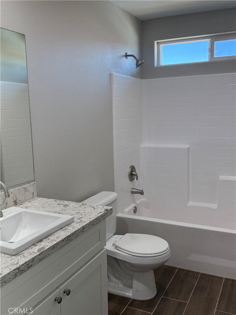 16506 Cactus Street Hesperia, CA 92345 - Photo 5 of 34 a bathroom with a granite countertop toilet a sink and a mirror