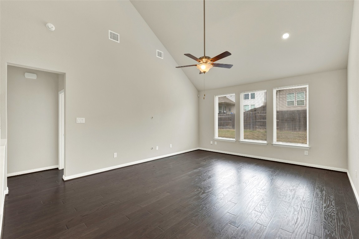 908 Leadtree Loop Buda, TX 78610 - Photo 13 of 38 a view of an empty room with wooden floor ceiling fan and a window