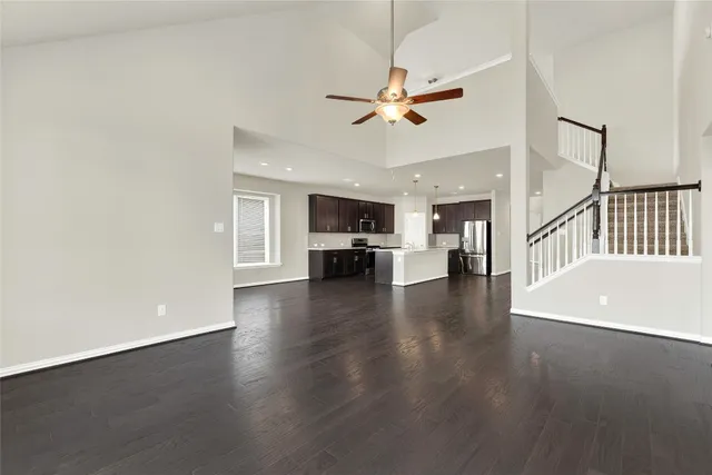 a view of a livingroom with furniture wooden floor and a ceiling fan
