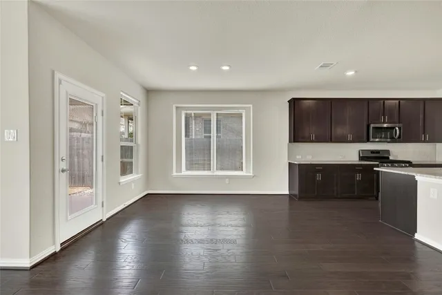 a kitchen with stainless steel appliances granite countertop a stove a sink and a microwave