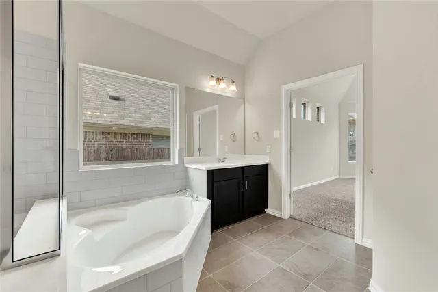 a spacious bathroom with a tub shower and sink