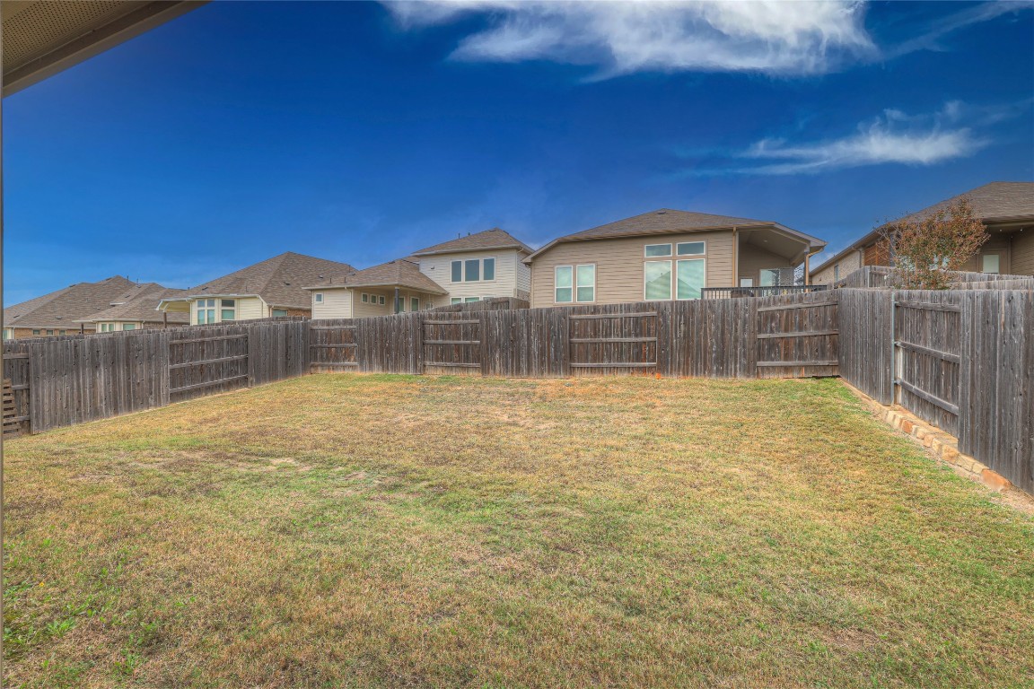908 Leadtree Loop Buda, TX 78610 - Photo 33 of 38 a view of large house with a wooden fence