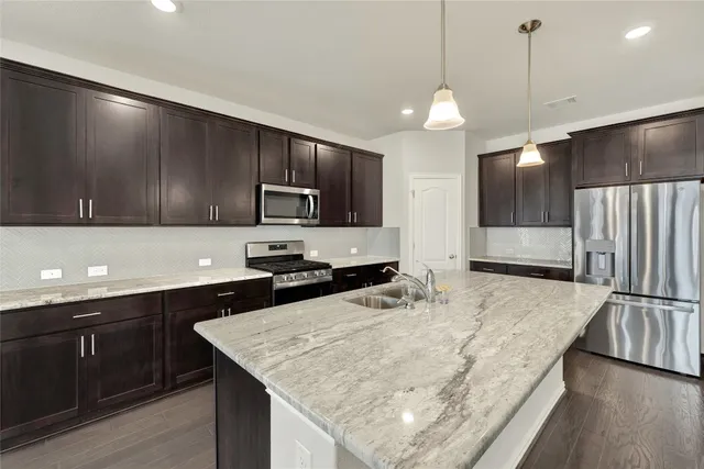 a kitchen with center island and stainless steel appliances