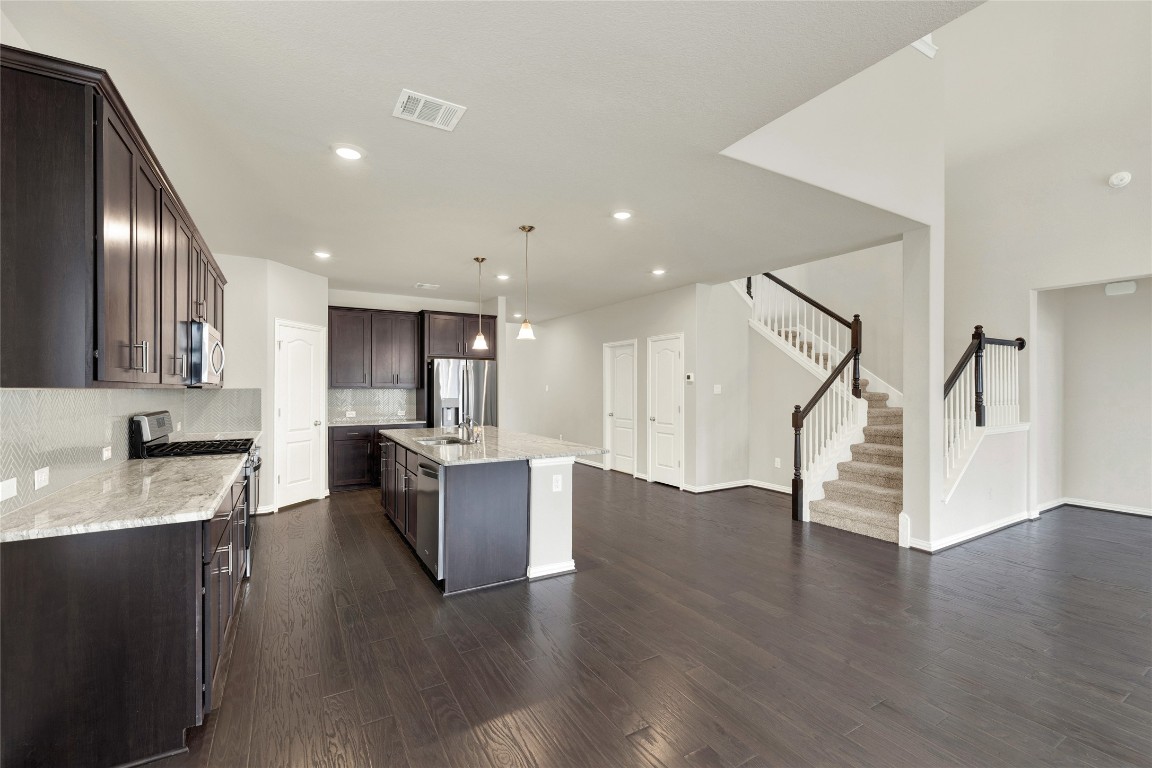 908 Leadtree Loop Buda, TX 78610 - Photo 9 of 38 a kitchen with a refrigerator and a sink