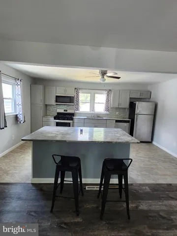 a kitchen with stainless steel appliances granite countertop a refrigerator and a stove top oven