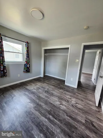 an empty room with wooden floor chandelier fan and windows