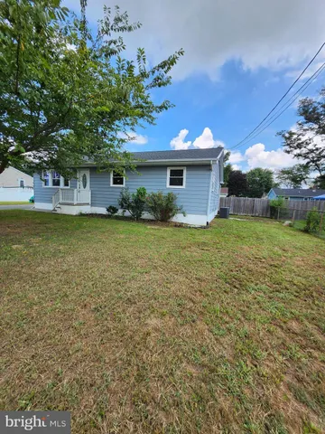 a view of a house with a yard and a large tree