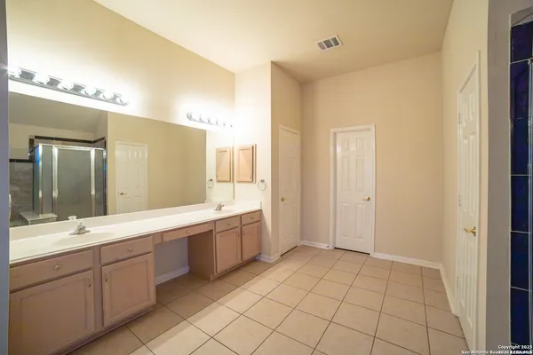 a spacious bathroom with a mirror sink and a shower