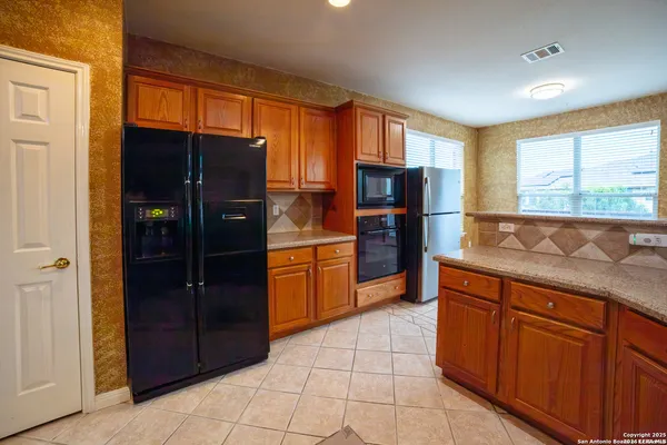 a kitchen with stainless steel appliances granite countertop a refrigerator and a sink