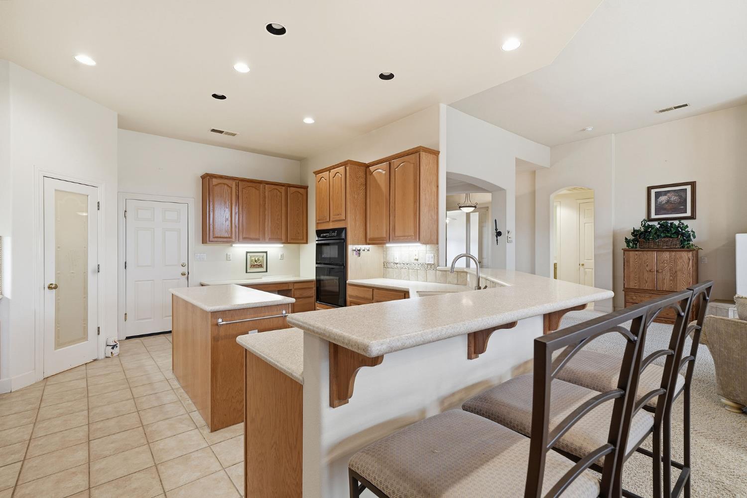 719 Shakeley Lane Ione, CA 95640 - Photo 12 of 68 a kitchen with stainless steel appliances granite countertop a table chairs sink and cabinets