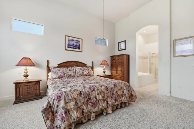 an empty room with chandelier fan and windows