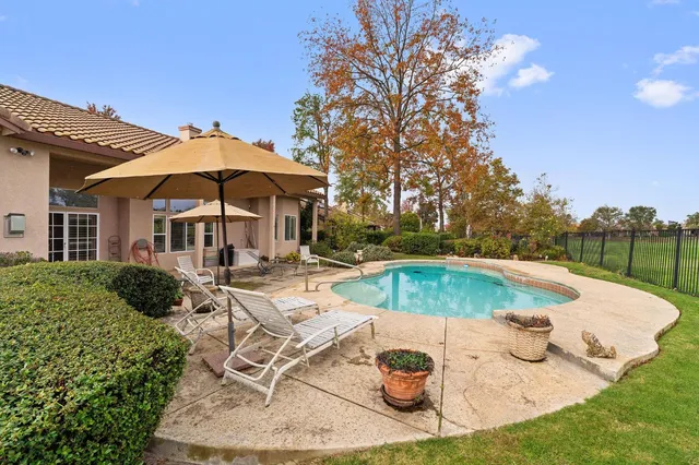 a kitchen with stainless steel appliances granite countertop a table chairs sink and cabinets