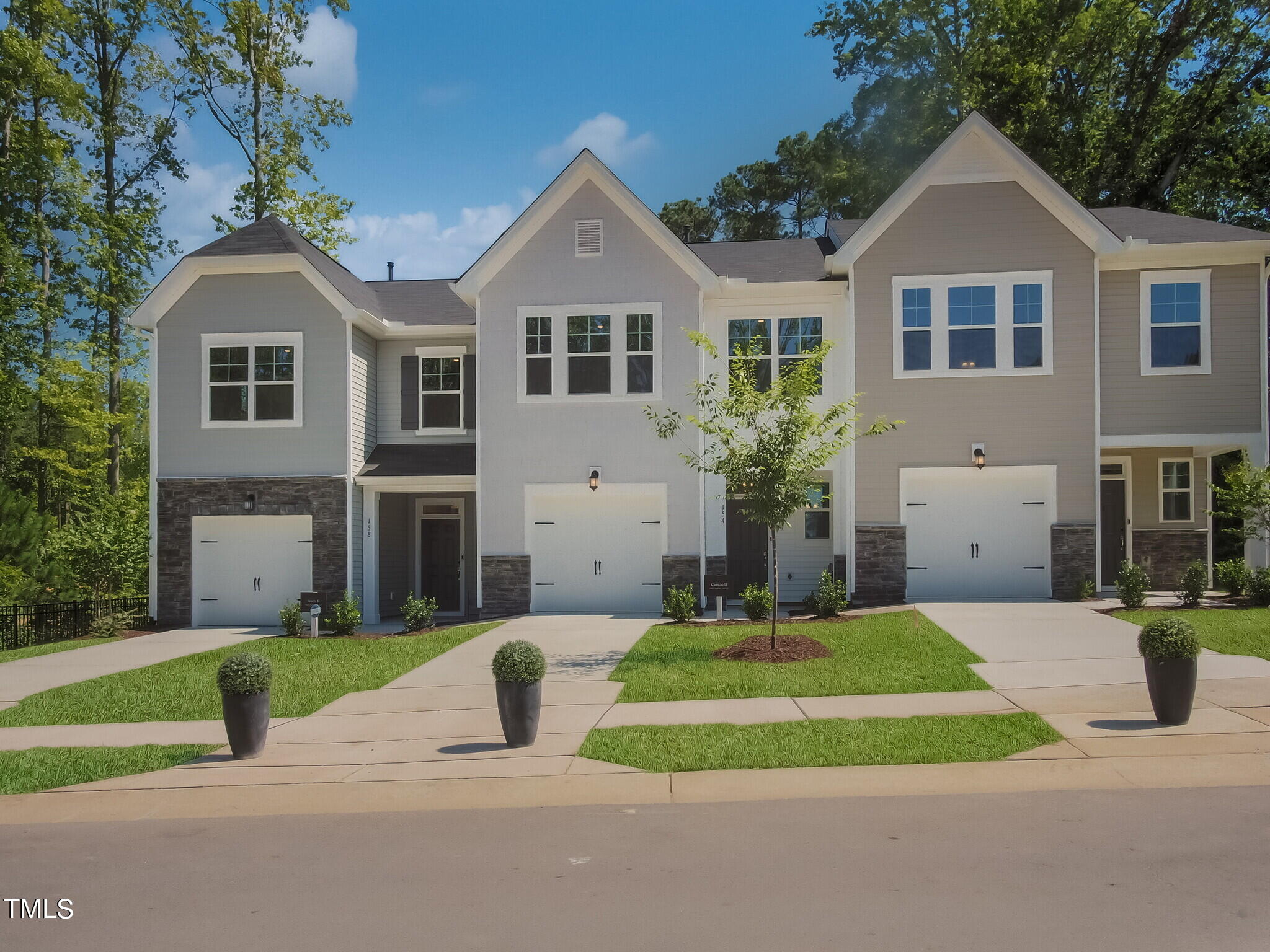 219 Aster Bloom Lane, Unit 394 Raleigh, NC 27610 - Photo 3 of 26 a front view of a house with a yard and garage