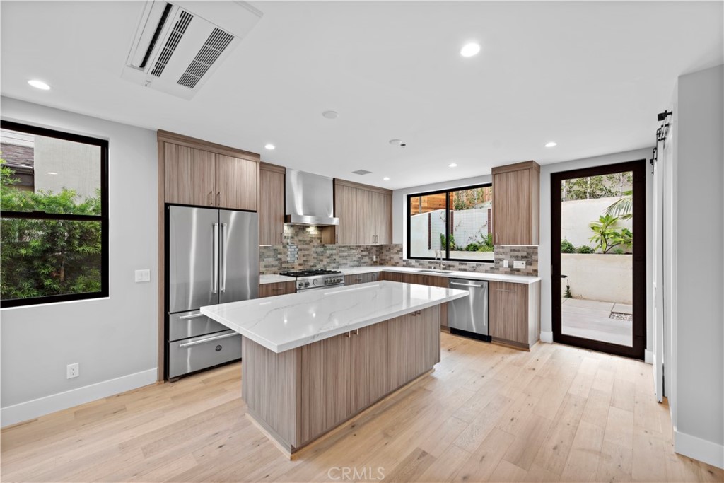 33903 Robles Drive Dana Point, CA 92629 - Photo 14 of 58 a large kitchen with kitchen island a large counter top space a sink stainless steel appliances and cabinets