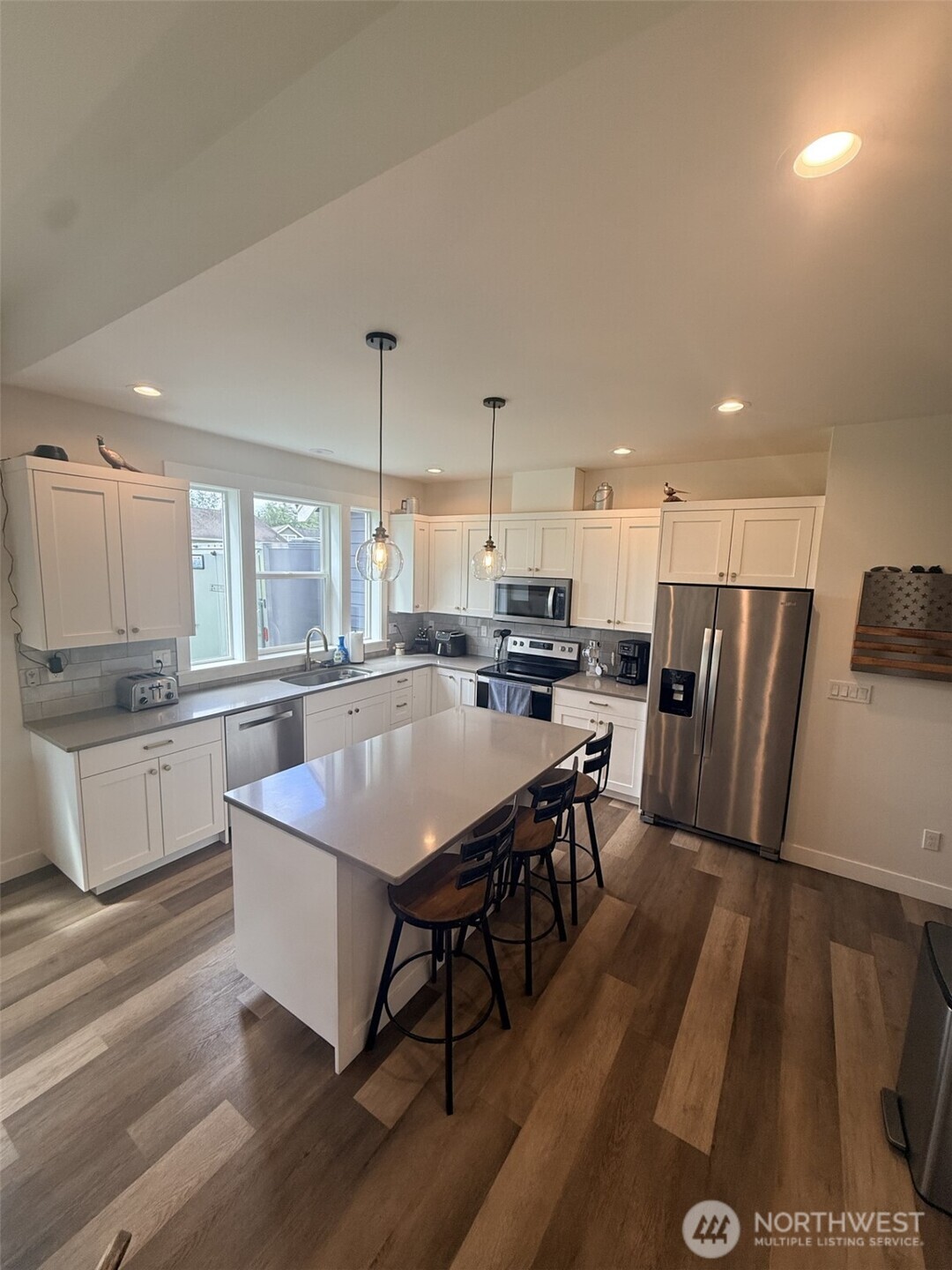 1200 Haystack Lane Everson, WA 98247 - Photo 10 of 16 a large kitchen with stainless steel appliances a refrigerator a stove a sink dishwasher with a dining table and chairs