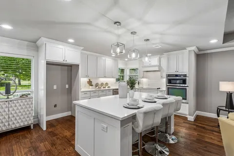 a kitchen with a dining table chairs refrigerator and cabinets