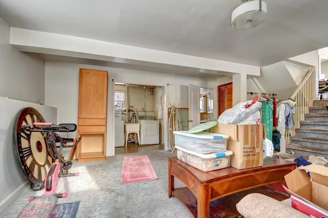 a living room with furniture a rug and gym equipment