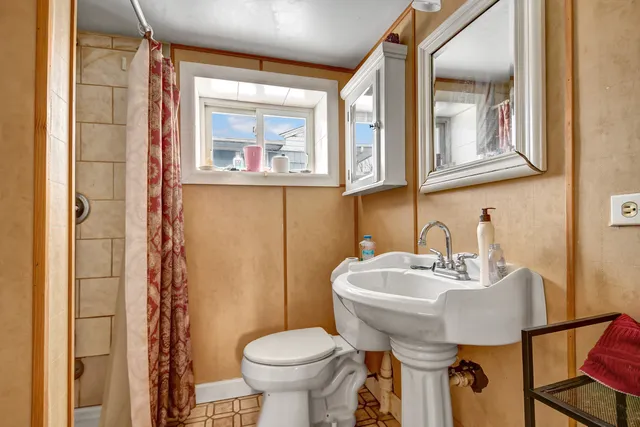 a bathroom with a sink toilet and mirror