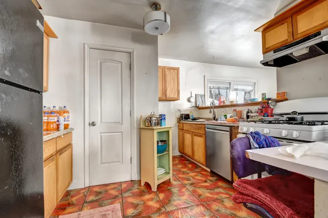 a kitchen with a refrigerator and a stove top oven