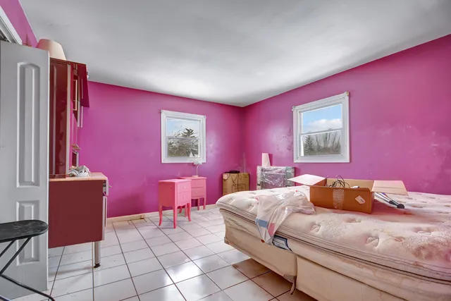 a bedroom with a bed and a dresser with mirror