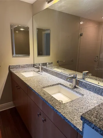 a bathroom with a granite countertop sink double and mirror