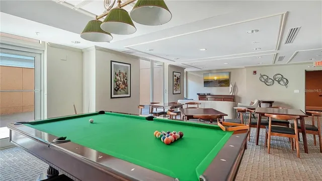 a room with pool table and windows