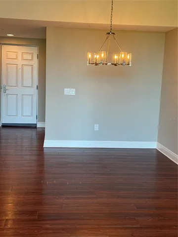 a view of a room with wooden floor and chandelier